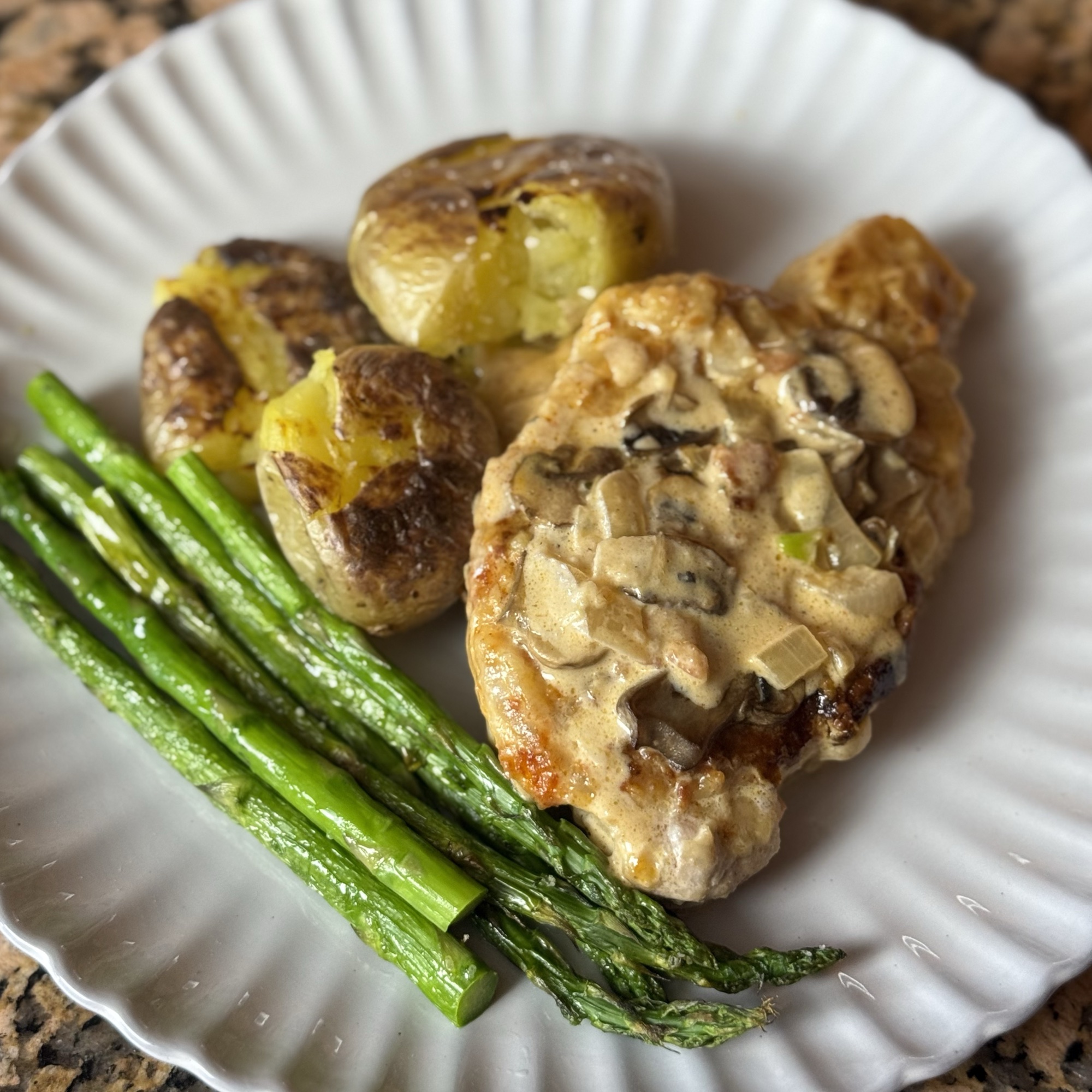 Chicken in mushroom sauce with roasted potatoes and asparagus, prepared by Doble Culinary